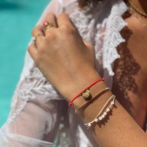 Boutique de bijoux à Toulouse : bracelet en cordon blanc avec des billes dorés mannequin porté