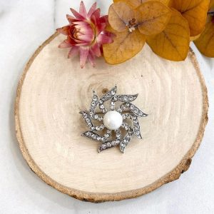 Boutique de bijoux à Toulouse : Broche fantaisie argenté en forme de fleur en spirale en strass et une perle blanche
