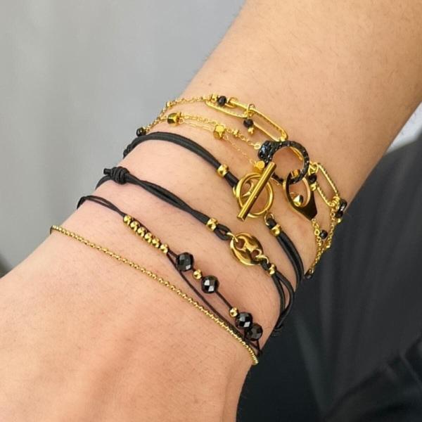 Boutique de bijoux à Toulouse : Mannequin qui porte un bracelet en acier inoxydable doré avec des petites menottes et des strass noirs