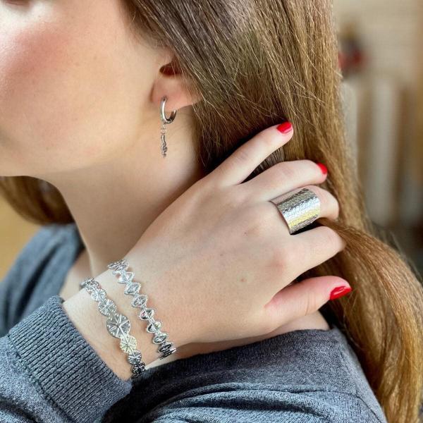 Boutique de bijoux à Toulouse : Mannequin qui porte un bracelet jonc ajustable en acier inoxydable argenté avec des cercles gravés d'étoiles polaires vue de près