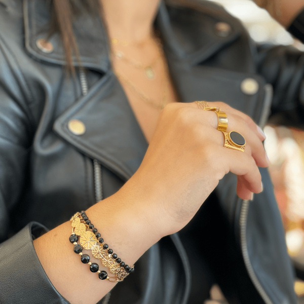 Boutique de bijoux à Toulouse : mannequin qui porte bracelet en acier inoxydable doré avec pierres naturelles rondes d'agate noire
