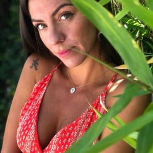 Boutique de bijoux à Toulouse : Mannequin qui porte un collier en acier inoxydable doré et sa médaille composée d'une croix et de strass blancs