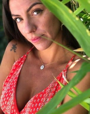 Boutique de bijoux à Toulouse : Mannequin qui porte un collier en acier inoxydable doré et sa médaille composée d'une croix et de strass blancs