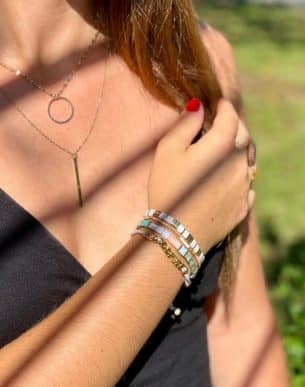 Boutique de bijoux à Toulouse : Mannequin qui porte un bracelet réglable rose avec des lettres en acier inoxydable doré