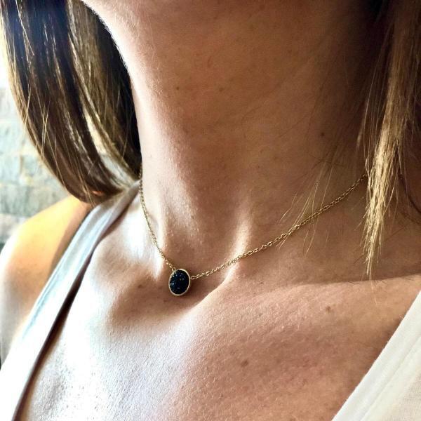 Boutique de bijoux à Toulouse : Mannequin qui porte un collier en acier inoxydable doré et sa médaille avec strass noirs