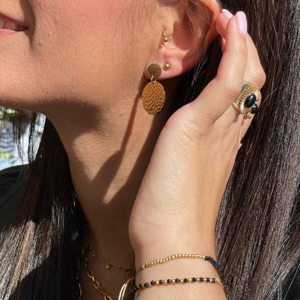 Boutique de bijoux à Toulouse : Mannequin qui porte des boucles d'oreilles pendantes en acier inoxydable doré avec médaille martelée