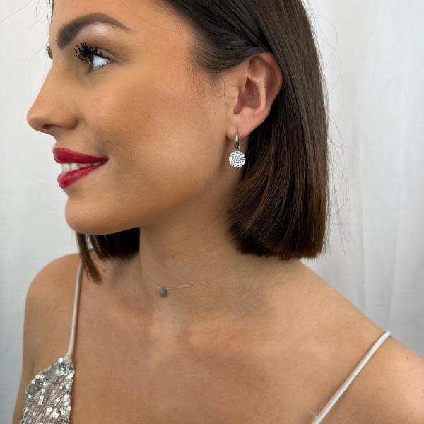 Boutique de bijoux à Toulouse : mannequin qui porte Boucles d'oreilles créoles en acier inoxydable argenté avec une médaille martelée