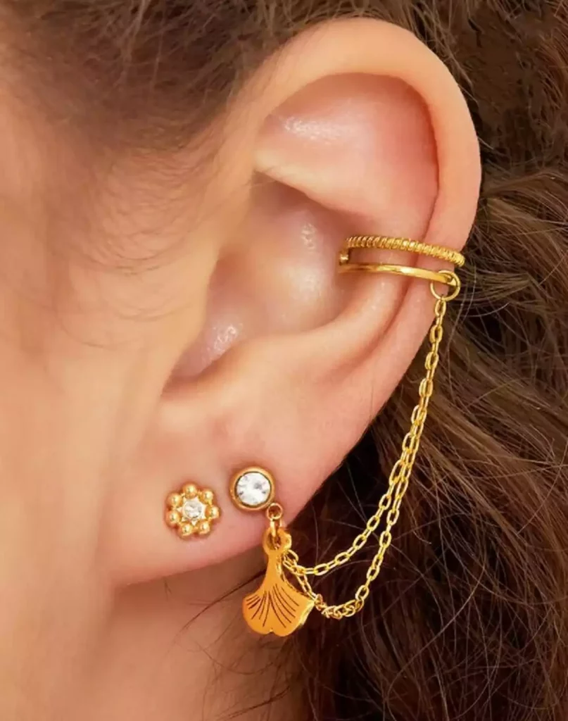 boucles d'oreille avec ear cuff doré en acier inoxydable avec une feuille de ginkgo sur mannequin